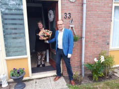 Wethouder reikt bloemen uit aan mantelzorger